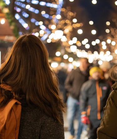 Two people walking through a lit-up market in Oslo.