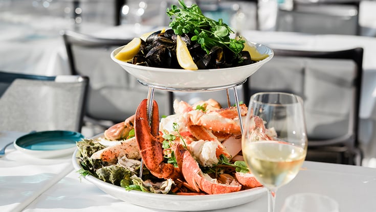 Two-tier seafood platter with wine served in Oslo.