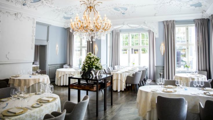 Elegant dining room with chandelier and table settings in Oslo.