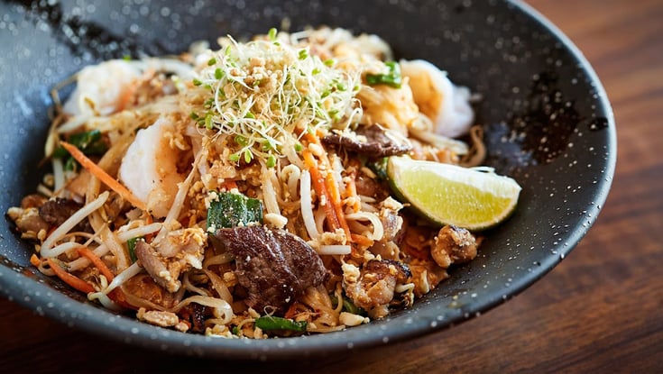 Noodle bowl with meat, vegetables, and lime served in Oslo.