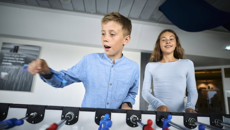 Two people playing table football indoors in the Matrosklubben.