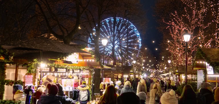Night market in Oslo with stalls and Ferris wheel.