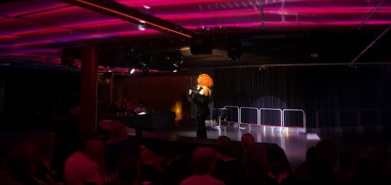 Performer with curly wig on stage.