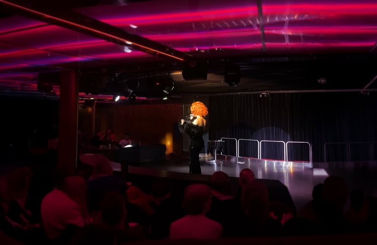 Performer with curly wig on stage.